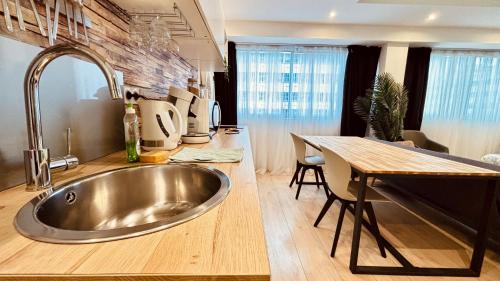 cocina con fregadero de acero inoxidable y mesa en ☆Loft 35m2 Lyon 6 Ménage inclus/pas de check out☆ en Lyon