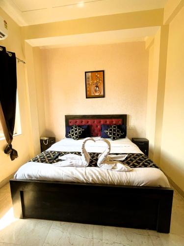 a bedroom with a large bed with a black frame at Hotel Grand Parador in Rishīkesh