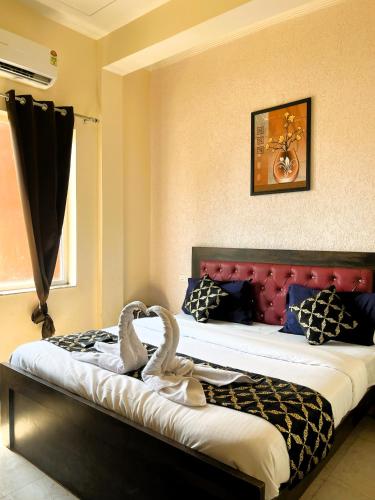 two swans sitting on a bed in a bedroom at Hotel Grand Parador in Rishīkesh