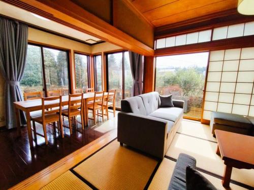 ein Wohnzimmer mit einer Couch und einem Tisch und Stühlen in der Unterkunft Nikko Big House - Max 12 Guests Near Station 2 Parking in Nikko