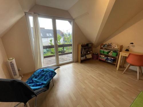 an attic room with a large window and a chair at 4 Guests: River & Garden Charm in Budapest