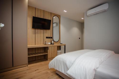 a bedroom with a white bed and a mirror at Oro Inn Hotel in Shkodër