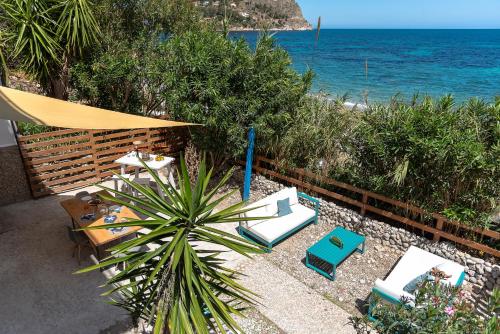 a patio with a table and chairs and the ocean at Dimore di mare - Beachfront Apartments in Santa Flavia