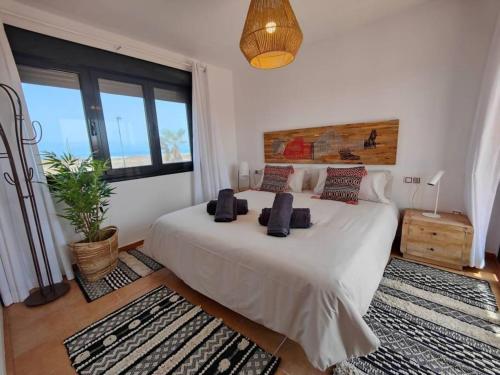 Un dormitorio con una gran cama blanca con almohadas. en Villa Moana Vistas al mar y Jacuzzi Lajares, en Lajares