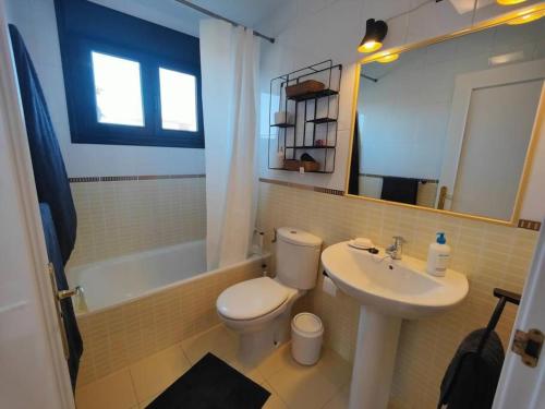 a bathroom with a white toilet and a sink at Villa Moana Vistas al mar y Jacuzzi Lajares in Lajares