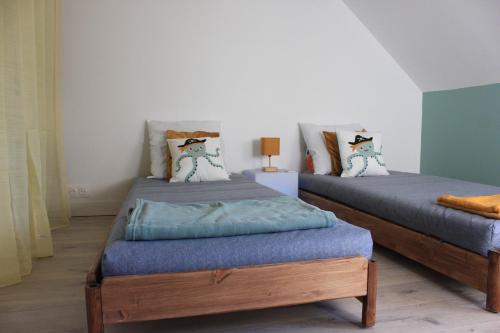 two twin beds in a room with at Les Jardins des 3 sœurs in Quettehou