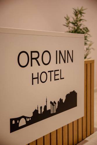 a sign for a one inn hotel on a wall at Oro Inn Hotel in Shkodër