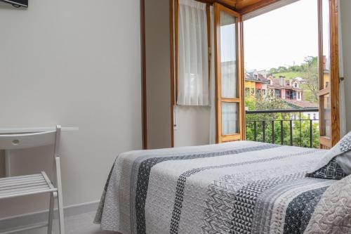a bedroom with a bed and a large window at Hotel Plaza in Cangas de Onís