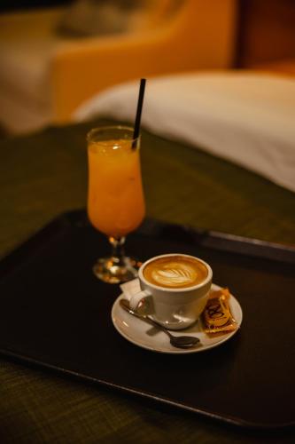 a cup of coffee on a tray with a drink at Oro Inn Hotel in Shkodër