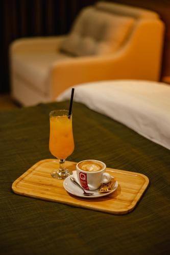 a tray with a cup of coffee and a glass of orange juice at Oro Inn Hotel in Shkodër