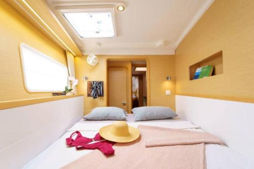 a room with two beds with a hat on top at Catamaran in San Blás Islands, private boat in Waisalatupo