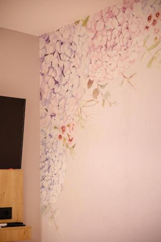 a wall mural of flowers on a wall at Oro Inn Hotel in Shkodër