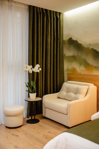 a room with a bed and a chair and a table at Oro Inn Hotel in Shkodër