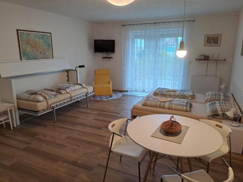 un soggiorno con 2 letti, tavolo e sedie di RIVIERA 510-2 Lipno a Lipno nad Vltavou