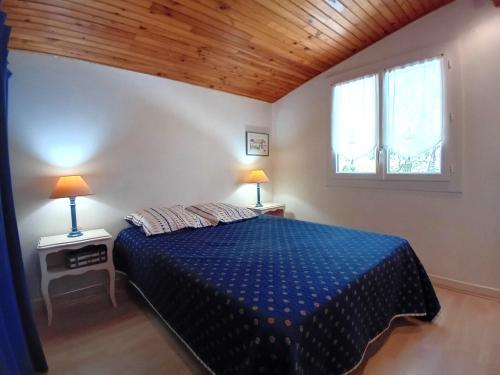 um quarto com uma cama azul num quarto com 2 candeeiros em Meschers sur Gironde - MAISON au CALME et en PLEINE NATURE - cœur de la FORET em Meschers-sur-Gironde