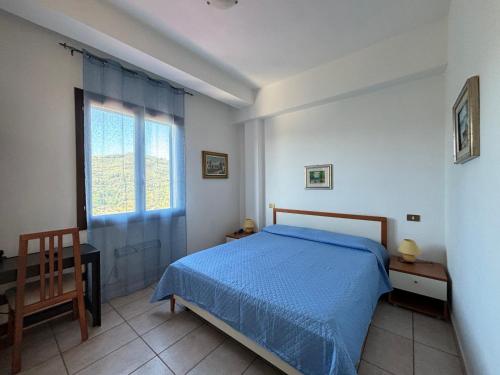 Un dormitorio con una cama azul y una ventana en Albergo Dolcedo, en Imperia