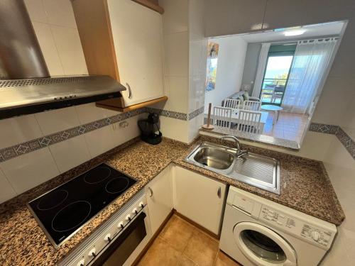 a kitchen with a sink and a washing machine at Apartamentos Mirador al Mar Altamar in Alcossebre