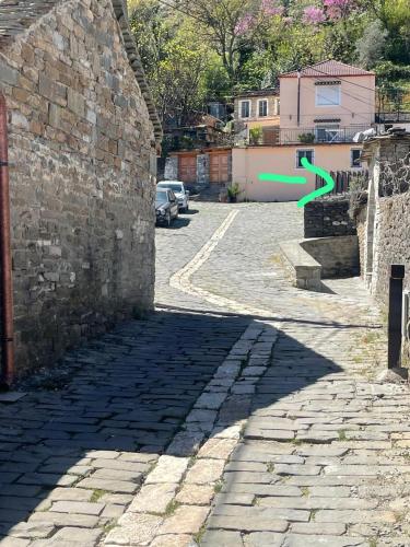 a shadow of a wall with a green arrow at Vila Culli in Përmet