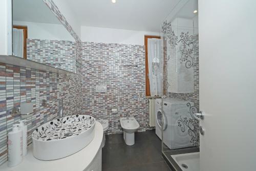a bathroom with a tub and a toilet and a sink at Residence Mimosa PT2 by Wonderful Italy in Toscolano Maderno