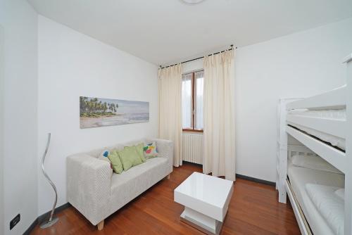 a white living room with a couch and a bed at Residence Mimosa PT2 by Wonderful Italy in Toscolano Maderno