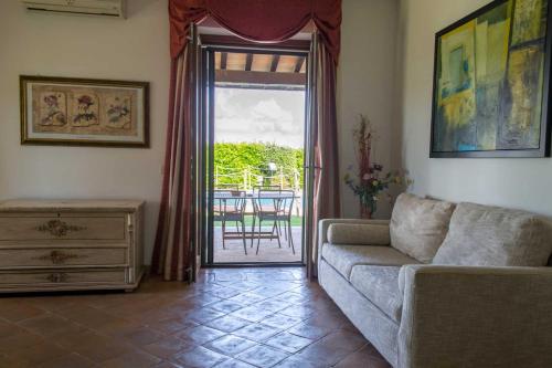 a living room with a couch and a sliding glass door at Agriturismo Poggio delle Conche in Pitigliano