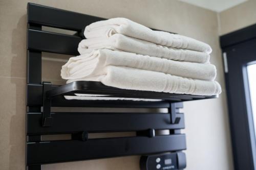 a stack of towels on a towel rack in a bathroom at LA PINTORESCA ''CIELO'' - TEATRO ROMANO MERIDA in Merida