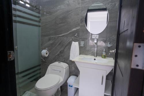 y baño con aseo, lavabo y espejo. en VILLA VIVA EVENTOS, en Puerto Cayo