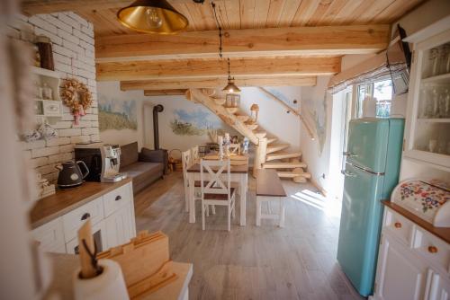 a kitchen and living room with a table and a refrigerator at Niezapominajka in Zbiczno