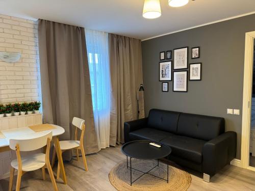 Una sala de estar con un sofá negro y una mesa. en ABSOLUT, en Narva