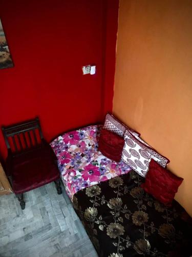 een kleine slaapkamer met een bed en een stoel bij Home Away From Home in Prayagraj