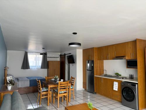 a kitchen and living room with a table and chairs at El Encanto Lofts in Cuernavaca
