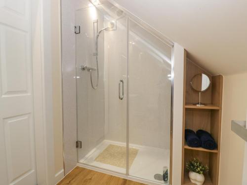 eine Dusche mit Glastür im Bad in der Unterkunft The Forest Coach House in Cinderford