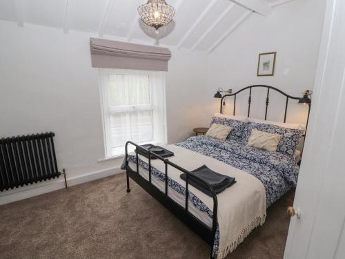 a bedroom with a bed and a window and a chandelier at Foxy Lady Cottage in Workington