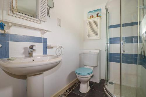 uma casa de banho com um lavatório, um WC e um chuveiro em Moonlight em Truro
