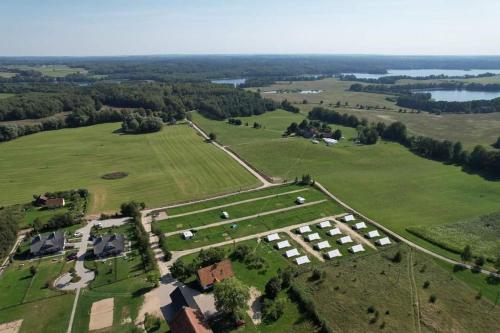 an aerial view of a large field with houses and trees at Glamping Szelągówka in Sorkwity