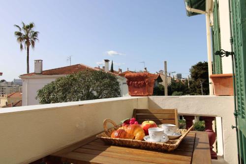 a basket of fruit on a table on a balcony at Appartement 1er étage Cottage Reine in Cannes