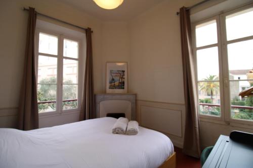 a bedroom with a bed with two white slippers on it at Appartement 1er étage Cottage Reine in Cannes