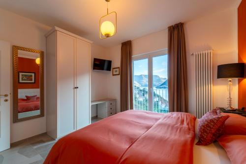 1 dormitorio con cama roja y ventana grande en Ka' Doro Deluxe, en Nesso