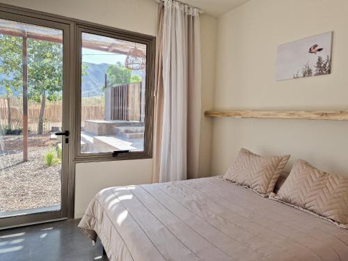 ein Schlafzimmer mit einem Bett und einem großen Fenster in der Unterkunft Miramonte Posada in Ciudad Lujan de Cuyo