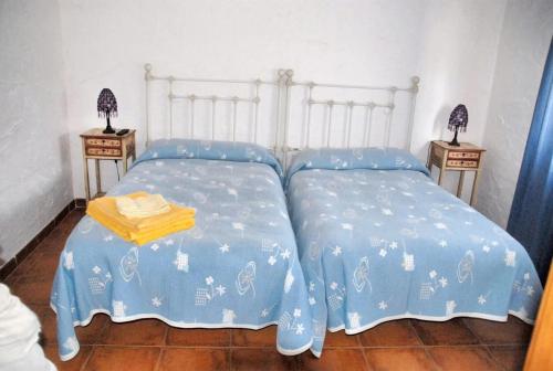 1 dormitorio con 2 camas con sábanas azules y 2 mesas en 6 bedrooms villa with private pool furnished terrace and wifi at Cerezo de Mohernando, en Cerezo de Mohernando