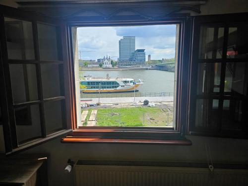 a window with a view of a river and a boat at Haus Enteresan in Cologne