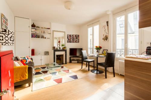 un salon avec une table et une cheminée dans l'établissement Welcome to Montmartre !, à Paris