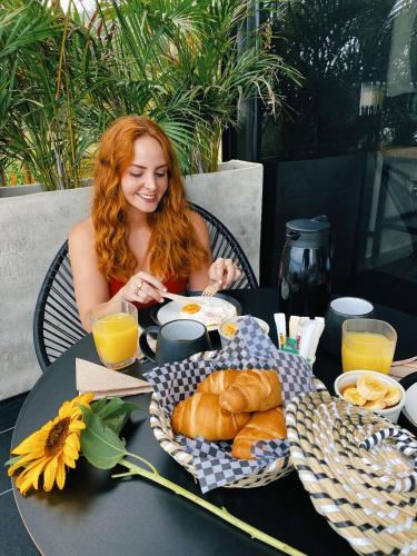 a woman sitting at a table with a plate of food at Hotel Boutique el Fique in Los Santos