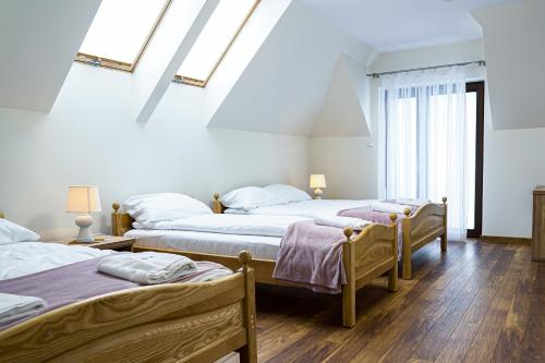 two beds in a room with white walls and wood floors at Spokojny Apartament u Słodyczki w Kluszkowcach in Kluszkowce