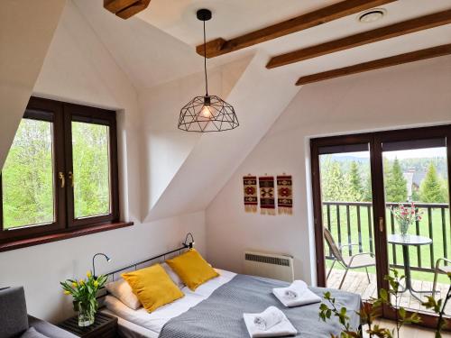 a bedroom with a bed and a balcony at Bojkowa Chata in Smerek