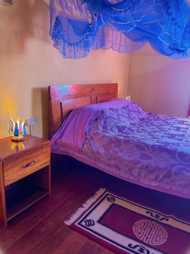 Schlafzimmer mit einem Bett, einem Tisch und einem Teppich in der Unterkunft Le Famanta - Hotel & Restaurant in Tolagnaro