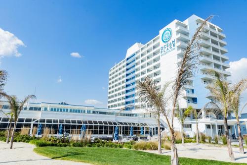 a large building with palm trees in front of it at Ocean Place Resort & Spa in Long Branch