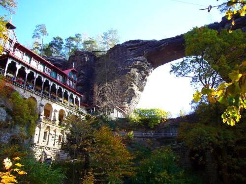 a building on a mountain with a bridge at Penzion Oáza Hřensko in Hřensko