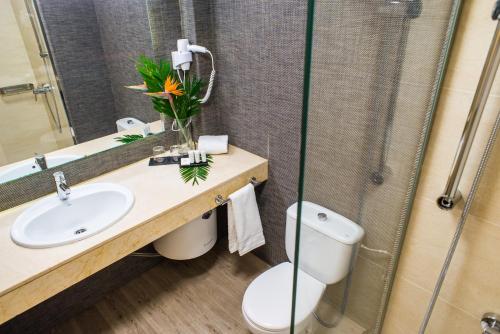 een badkamer met een toilet, een wastafel en een douche bij Dunas Club - Hotel & Apartamentos in Corralejo