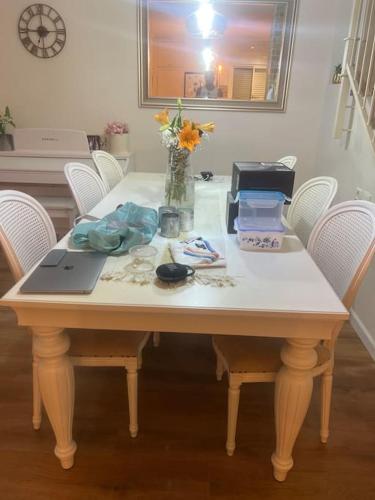 uma mesa com um laptop e um vaso de flores sobre ele em בית כפרי בנורדיה em Gannot Hadar